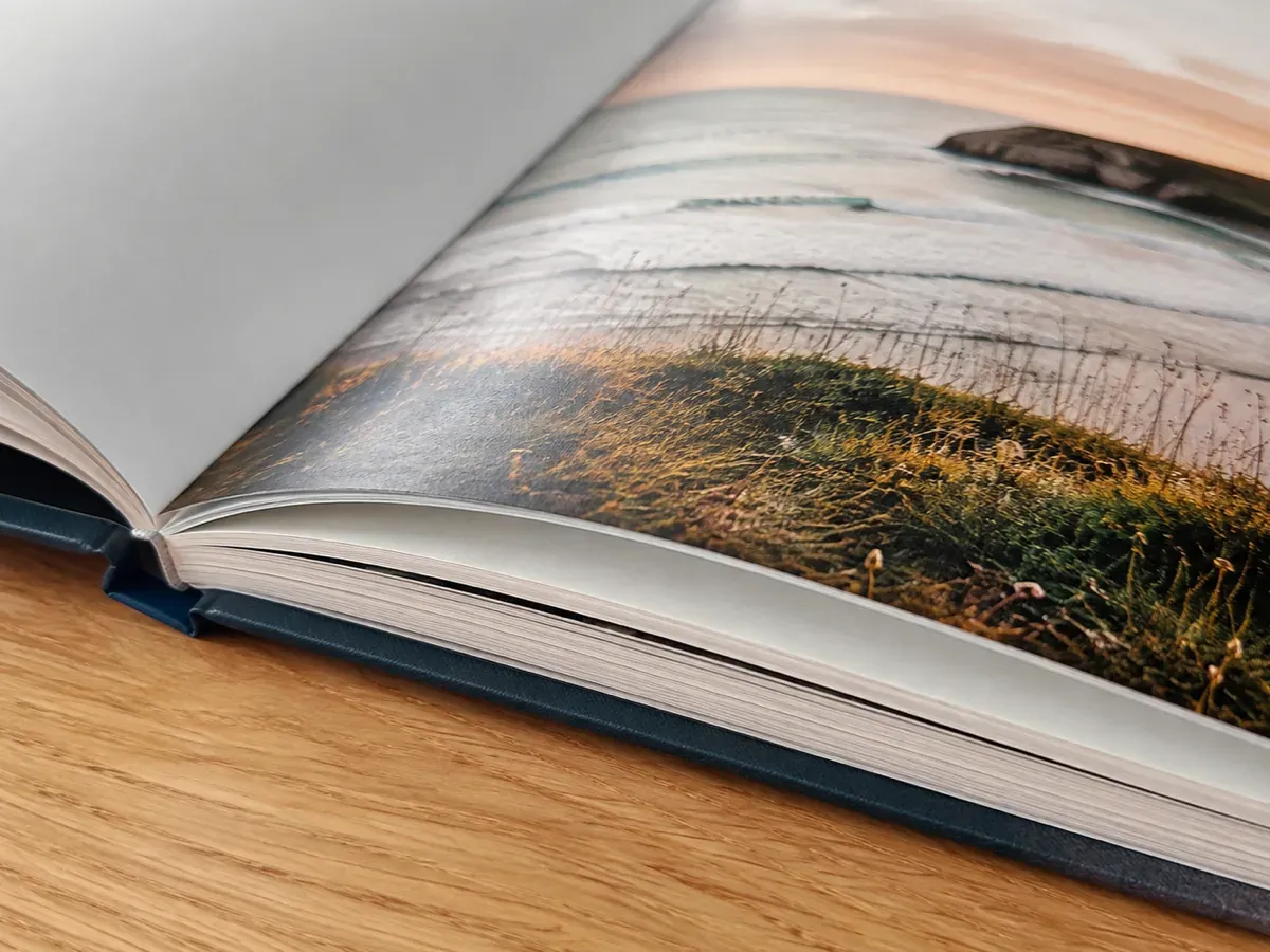 Gros plan sur la reliure cousue et l’épaisseur des pages du livre rigide